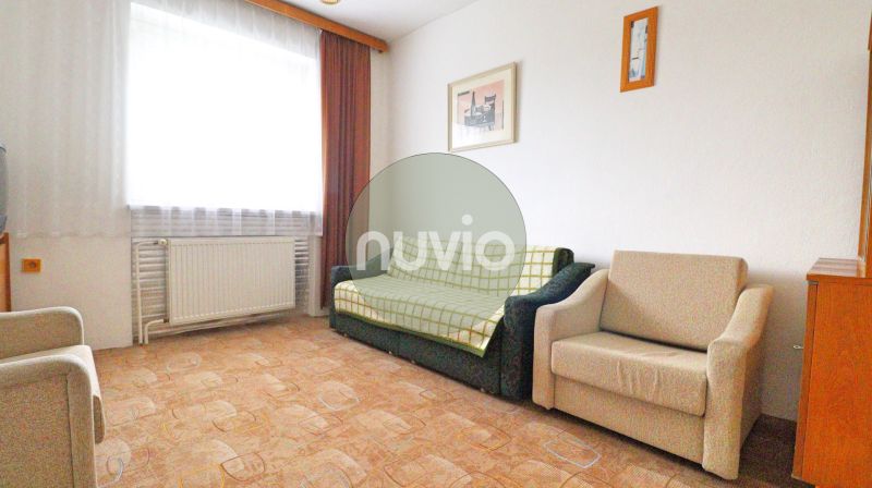 STRÁNE - 5 izbový rodinný dom na predaj - Obývacia izba s pohovkou, kreslom, obrazmi na stene, podlaha s dreveným dekorom.