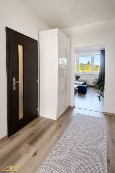 Prenájom: moderný 2-izbový byt s balkónom, Čadca SNP - Chodba v 2-izbovom byte s podlahou s dreveným dekorom, vedúca do obývacej izby.