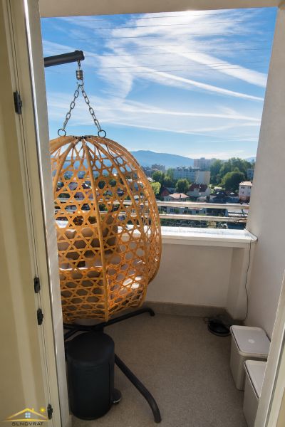 Prenájom: moderný 2-izbový byt s balkónom, Čadca SNP - Balkón v 2-izbovom byte s ratanovým kreslom a výhľadom na mesto.