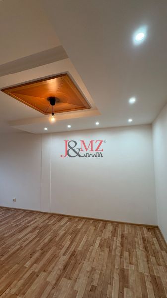 Slnečný 2-izbový byt vo vynikajúcej lokalite – stačí dokončiť kuchyňu  - Stropná lampa a podlaha s dreveným dekorom v 2-izbovom byte.
