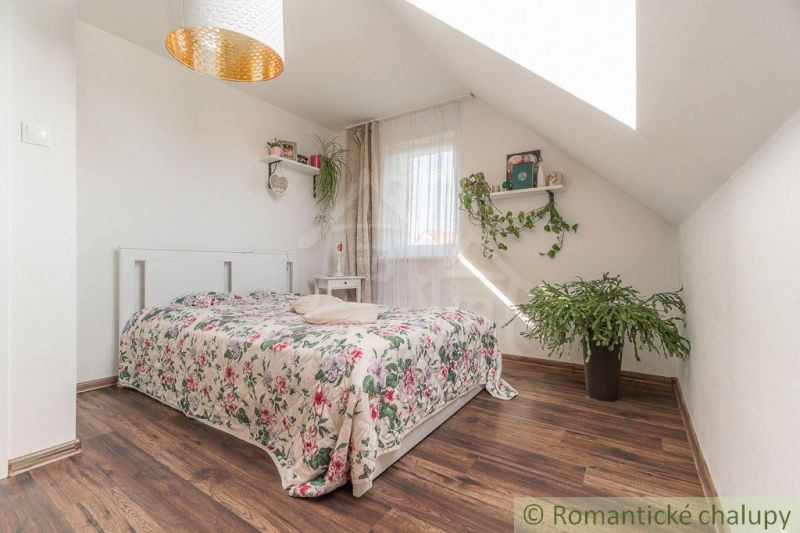 Komfortný dom v pokojnej záhradkárskej oblasti v Bernolákove - Svetlá spálňa v rodinnom dome s podlahou s dreveným dekorom a rastlinami.
