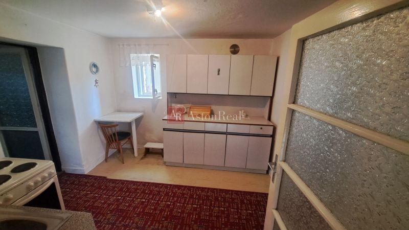 RODINNÝ DOM, pozemok 290m2,  MEDZIBROD okr. Banská Bystrica   - Kuchyňa v rodinnom dome s kuchynskou linkou, stoličkou a malým stolom.