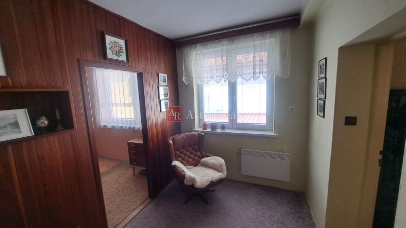 RODINNÝ DOM, pozemok 290m2,  MEDZIBROD okr. Banská Bystrica   - Pohodlné kreslo, záclony na okne a obklady v rodinnom dome vytvárajú útulnú atmosféru.