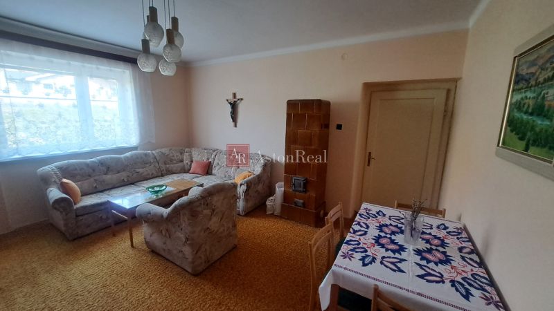RODINNÝ DOM, pozemok 290m2,  MEDZIBROD okr. Banská Bystrica   - Obývacia izba s rohovou sedačkou a kachľovou pecou v rodinnom dome.