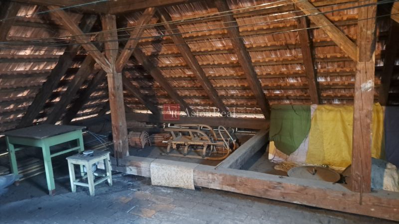RODINNÝ DOM, pozemok 290m2,  MEDZIBROD okr. Banská Bystrica   - Podkrovie rodinného domu s drevenými trámami a jednoduchým nábytkom.