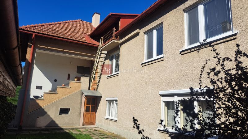 DVOJGENERAČNÝ DOM,  MEDZIBROD okr. Banská Bystrica   - Rodinný dom v Medzibrode s vonkajším schodiskom a bielymi oknami.