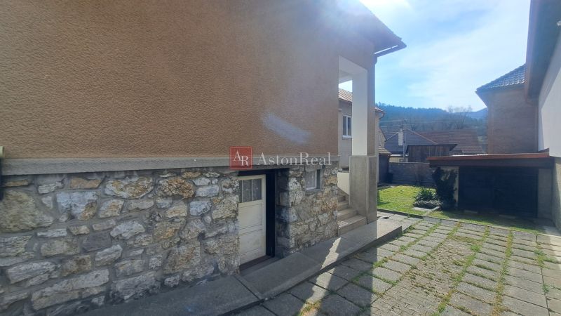 DVOJGENERAČNÝ DOM,  MEDZIBROD okr. Banská Bystrica   - Rodinný dom v Medzibrode s kamenným soklom, dvoma dverami a vstupnými schodmi.