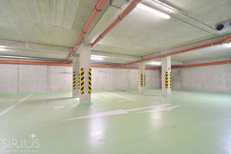 UZBECKÁ, parkovacie miesto v garáži, novostavba Oppidum - Podzemná garáž s pruhovanými stĺpmi a oranžovým potrubím, čisté parkovacie miesta.