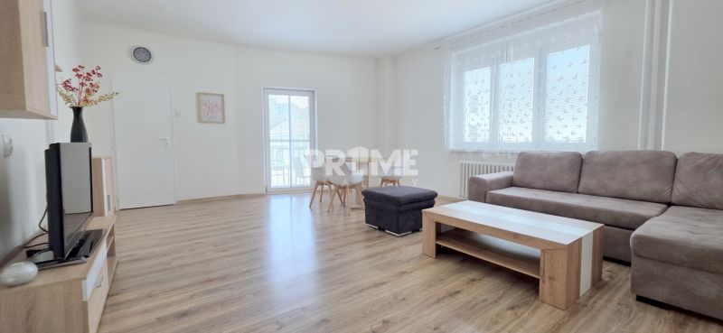  PRIESTRANNÝ 2i byt, BLUMENTÁL, CENTRUM, LOGGIA, Wilsonova ulica - Svetlá obývačka v 2-izbovom byte so sedačkou a televíziou na drevenej podlahe.