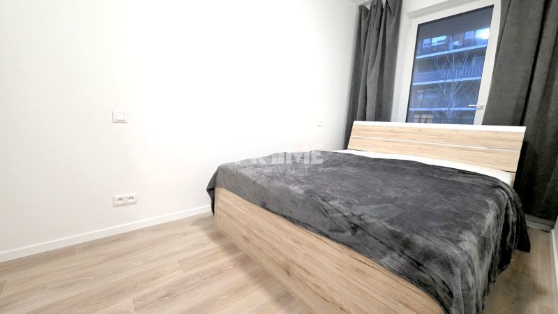U NÁS !!! MODERNÝ 2i,NOVOSTAVBA, LOGGIA, Slnečnice UNIQ, Fialova ulica - Spálňa s posteľou a podlahou s dreveným dekorom v 2-izbovom byte.