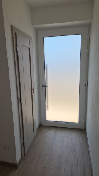 Bungalov v centre obce Cabaj v štandarde, Wágnerova ulica, Dom č.2 - Predsieň v rodinnom dome s podlahou s dreveným dekorom a matným skleneným dverom.