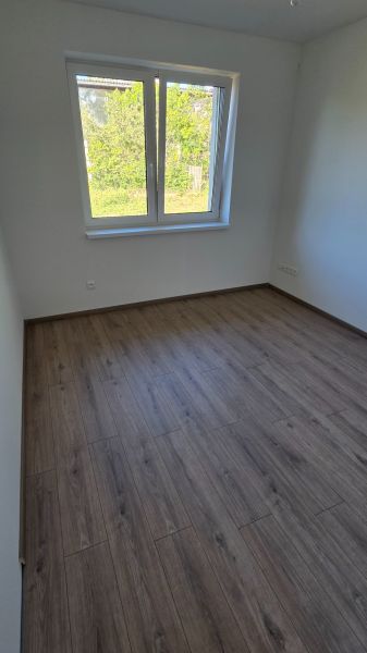 Bungalov v centre obce Cabaj v štandarde, Wágnerova ulica, Dom č.2 - Izba s podlahou s dreveným dekorom, okno s výhľadom do záhrady v rodinnom dome.