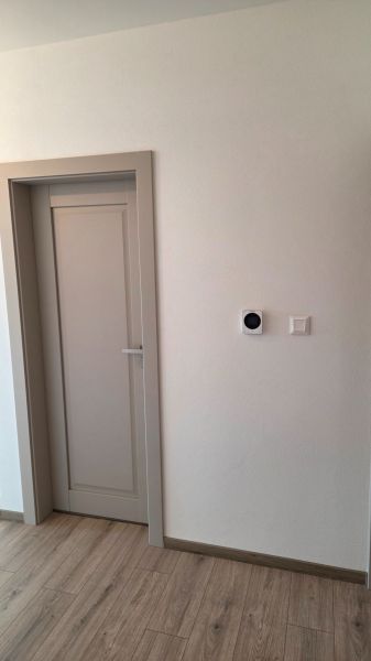 Bungalov v centre obce Cabaj v štandarde, Wágnerova ulica, Dom č.2 - Dvere v rodinnom dome s podlahou s dreveným dekorom a bielou stenou.