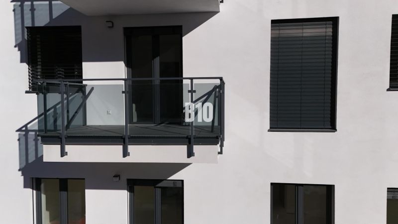 3 izbový byt v novostavbe REZIDENCIA KUBÍN - Exteriér 2-izbového bytu v Dolnom Kubíne s preskleným balkónom a uzavretými žalúziami.