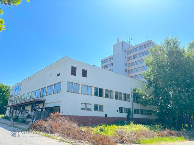 FORVIN TOWER - Predaj administratívnej budovy, Veľký Krtíš - Budova na ulici so zeleňou a zväčša prázdnymi oknami, zvláštne nehnuteľnosti.