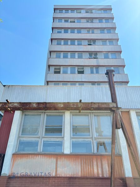 FORVIN TOWER - Predaj administratívnej budovy, Veľký Krtíš - Budova na ulici Liaz so zvláštnou nehnuteľnosťou, poschodia, okná, modrá obloha.