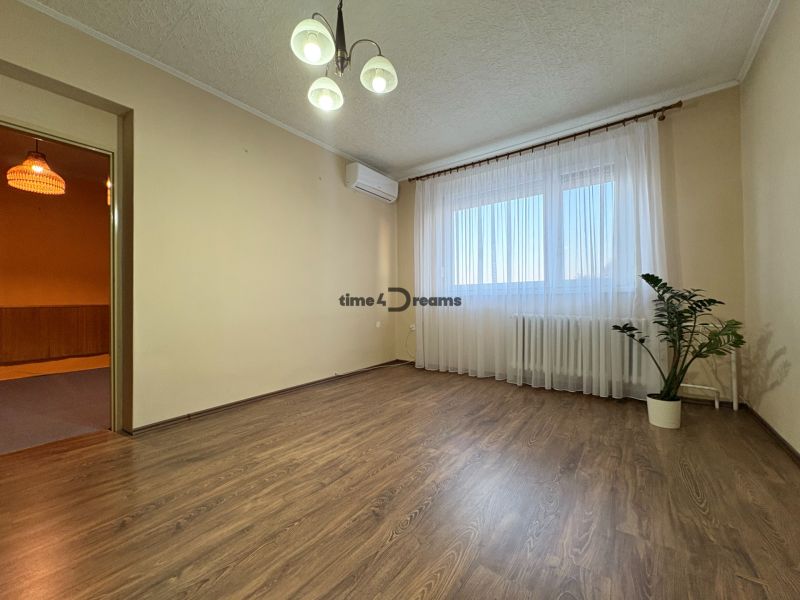Na predaj: CENTRUM 3 izb.byt + LOGGIA + KLÍMA + PIVNICA - Izba v 3-izbovom byte s podlahou s dreveným dekorom a záclonami.