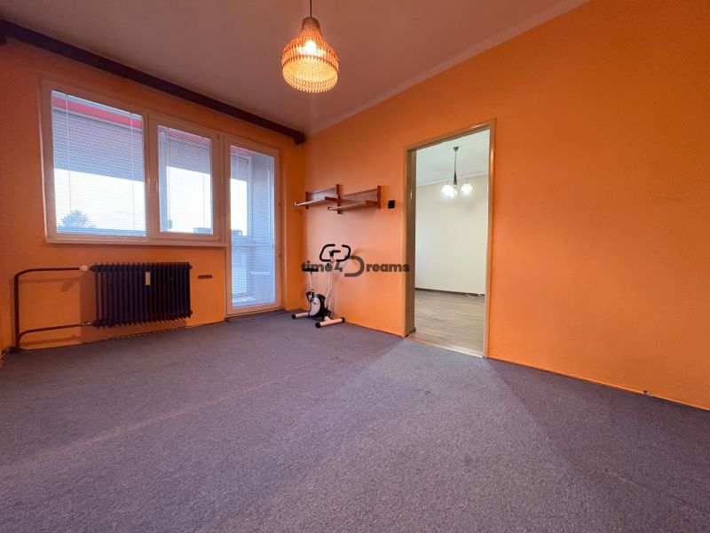 Na predaj: CENTRUM 3 izb.byt + LOGGIA + KLÍMA + PIVNICA - Izba s oranžovými stenami, balkónovými dverami a kobercom v 3-izbovom byte.