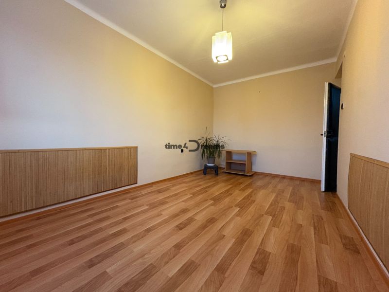 Na predaj: CENTRUM 3 izb.byt + LOGGIA + KLÍMA + PIVNICA - Obývacia izba v 3-izbovom byte s podlahou s dreveným dekorom a minimalistickým nábytkom.