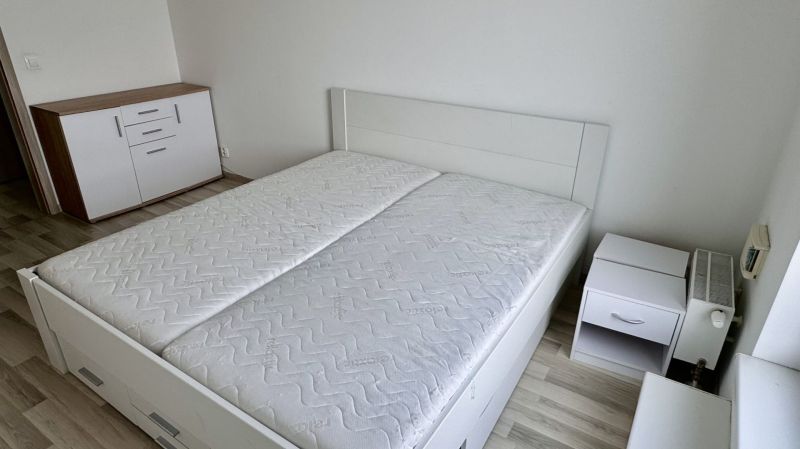 4 izbový byt 150 m2 novostavba Petržalka v Slnečniciach  s terasou, 2x - Spálňa v 4-izbovom byte s posteľou, skrinkou a podlahou s dreveným dekorom.