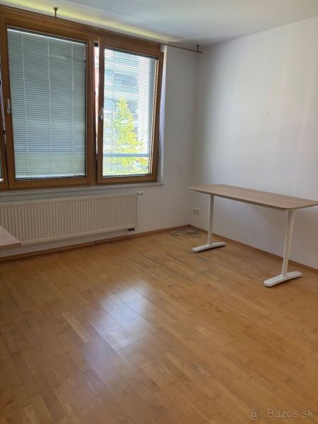 4 izbový byt 120 m2 Ružová dolina, Ružinov, 1x podzemné´parkovanie - Izba v 4-izbovom byte s stolom, oknami a podlahou s dreveným dekorom.