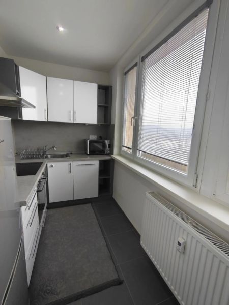 2-izbový na Dargovských hrdinov - Kuchyňa v 2-izbovom byte s bielymi skrinkami a veľkým oknom.
