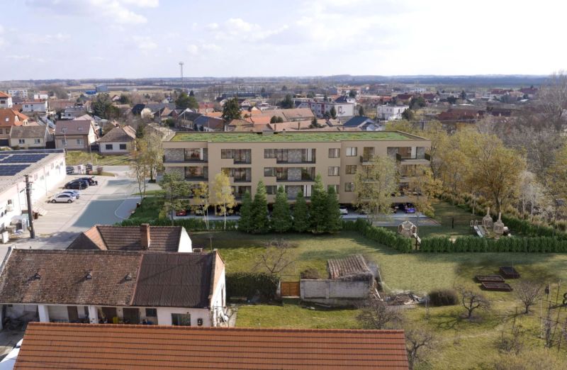 Developerský projekt SRDCE GROBU! - Budova obklopená zeleňou v zastavanej časti mesta, s výhľadom na susedné domy.