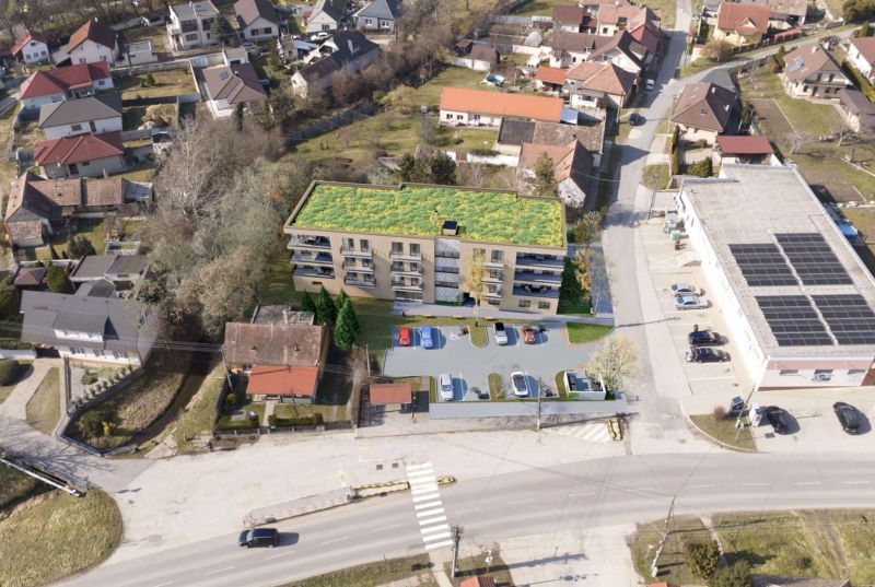 Developerský projekt SRDCE GROBU! - Letecký pohľad na bytový dom s parkoviskom a zelenou strechou v obytnej zóne.