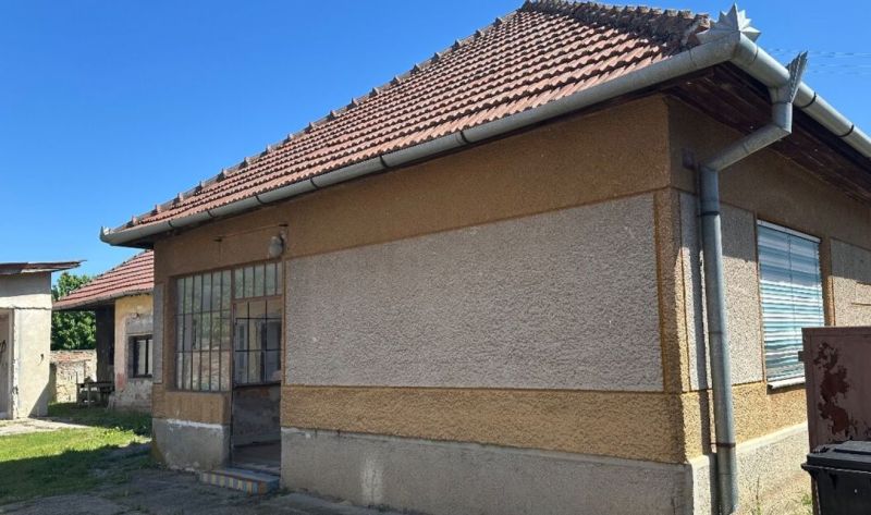 Na predaj rodinný dom s veľkým pozemkom v tichej lokalite - Rodinný dom v Močenku s šikmou strechou a presklenými dverami na slnečnom dvore.