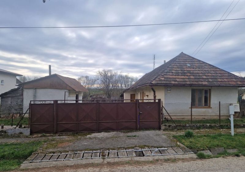 Rodinný dom s veľkým pozemkom v obci Kolta - Rodinný dom v Kolte s bránou, plotom a sedlovou strechou v pokojnom prostredí.