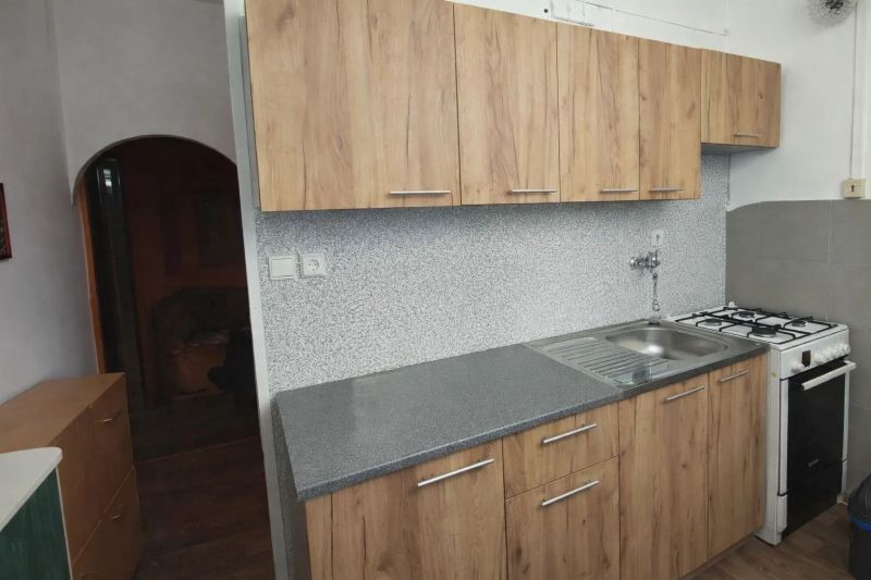 Prenájom 2 izbový byt Poprad - loggia - Kuchynská linka s drevodekorom a šedou doskou v 2-izbovom byte, plynový sporák.