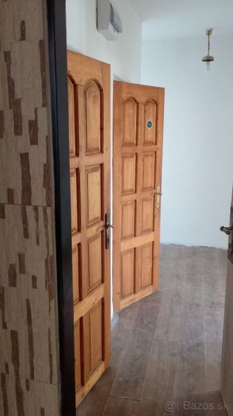 Na predaj priestranný 2-izbový byt 56m2– Košice, Lomená ulica - Interiér 2-izbového bytu s drevenými dverami a podlahou s dreveným dekorom.