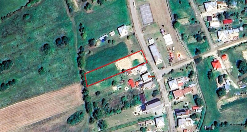 Na predaj stavebný pozemok o rozlohe - 2050 m² v obci Karná cca.15min. - Letecký pohľad na pozemok na bývanie v Kárnej, obklopený zeleňou a budovami.