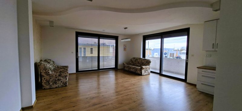 Na prenájom nadštandardný 2-izbový byt - 65 m² v centre Vranova nad To - Obývačka 2-izbového bytu s podlahou s dreveným dekorom a veľkými oknami.