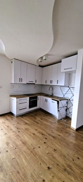 Na prenájom nadštandardný 2-izbový byt - 65 m² v centre Vranova nad To - Kuchyňa v 2-izbovom byte s bielymi skrinkami a podlahou s dreveným dekorom.