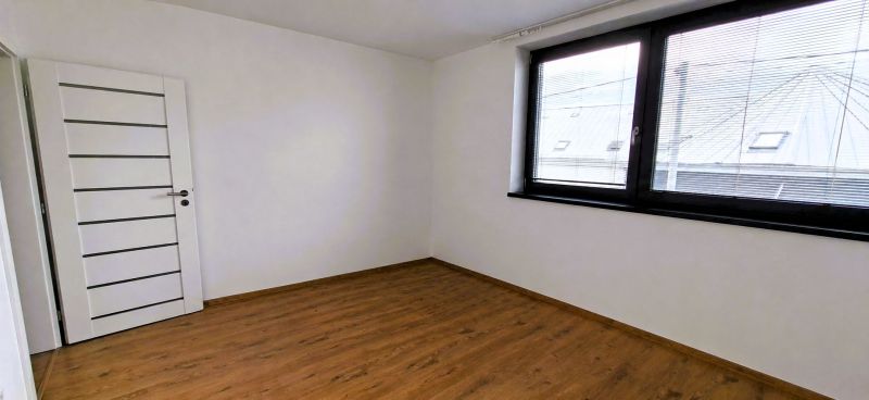 Na prenájom nadštandardný 2-izbový byt - 65 m² v centre Vranova nad To - Izba s podlahou s dreveným dekorom a veľkým oknom v 2-izbovom byte.