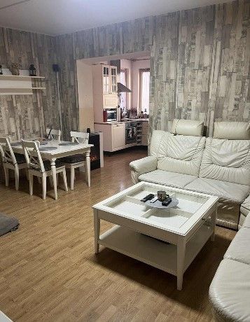Dom na bývanie a podnikanie na 15 ár. pozemku 35 km od BA - Obývačka s podlahou s dreveným dekorom, bielym nábytkom, jedálenským stolom a kuchynkou.