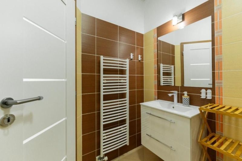 Moderný apartmán v centre Rajeckých Teplíc rovno oproti kúpeľom Afrodi - Kúpeľňa v Rekreačnom apartmáne s umývadlom, zrkadlom a rebríkovým radiátorom.