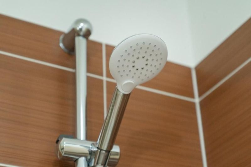 Moderný apartmán v centre Rajeckých Teplíc rovno oproti kúpeľom Afrodi - Sprchová hlavica v Rekreačnom apartmáne s obkladom v prírodnom odtieni.