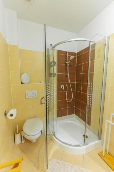 Moderný apartmán v centre Rajeckých Teplíc rovno oproti kúpeľom Afrodi - Kúpeľňa v Rekreačnom apartmáne s oblou sprchou a béžovým obkladom.