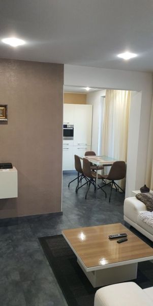 Nadštandardný, dômyselne zariadený 3-izbový byt  - PREDAJ. - Obývacia izba s tmavou podlahou a pohľadom na jedálenský kút v 3-izbovom byte.