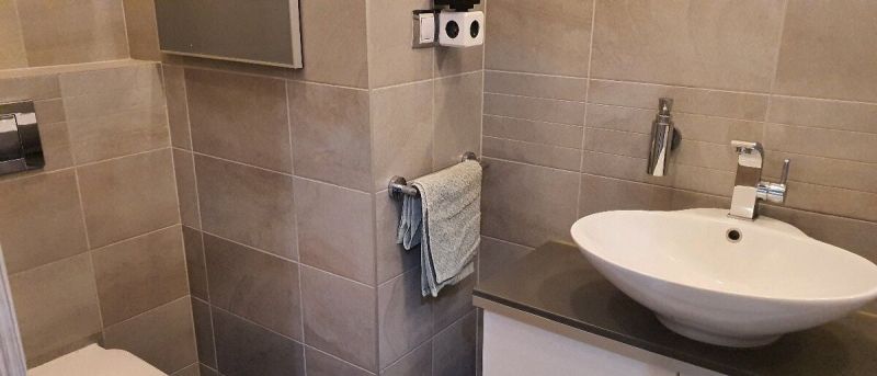 Nadštandardný, dômyselne zariadený 3-izbový byt  - PREDAJ. - Kúpeľňa so svetlými dlaždicami a bielym umývadlom v 3-izbovom byte.