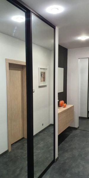Nadštandardný, dômyselne zariadený 3-izbový byt  - PREDAJ. - Predsieň so zrkadlovou skriňou v 3-izbovom byte, podlaha s dreveným dekorom.