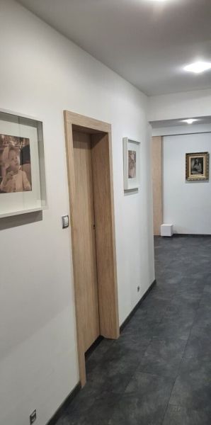 Nadštandardný, dômyselne zariadený 3-izbový byt  - PREDAJ. - Chodba s umením na stenách v 3-izbovom byte, podlaha s dreveným dekorom.