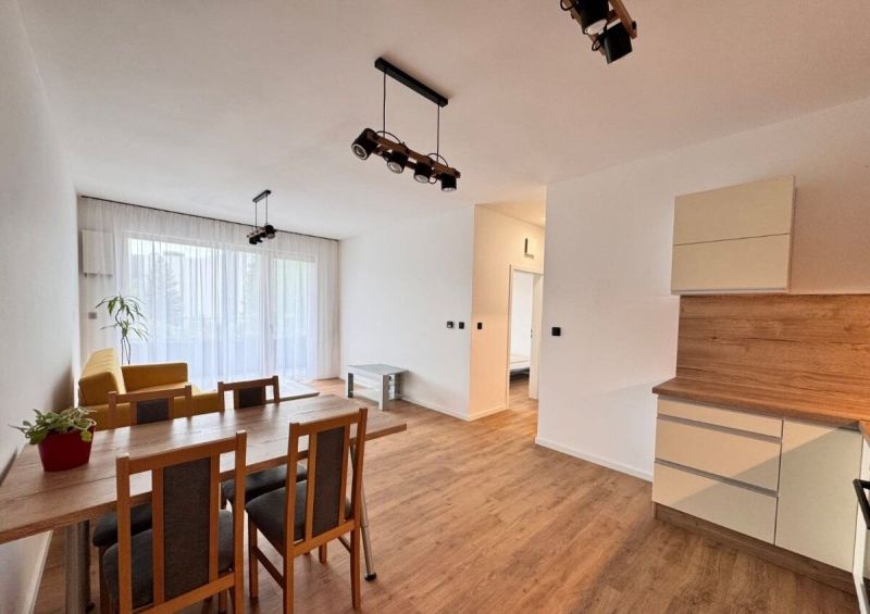 Prenájom nový 2-izbový byt -49m² Žilina-Vlčince, EUROTERRACE - Jasný obývací priestor s jedálenským stolom a podlahou s dreveným dekorom.