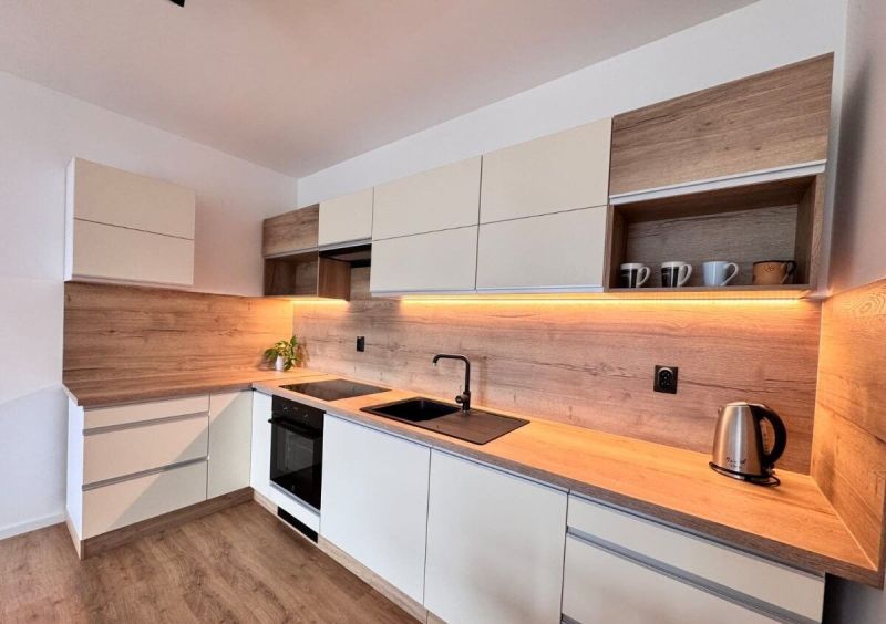 Prenájom nový 2-izbový byt -49m² Žilina-Vlčince, EUROTERRACE - Kuchyňa v 2-izbovom byte s podlahou s dreveným dekorom a LED osvetlením pod skrinkami.