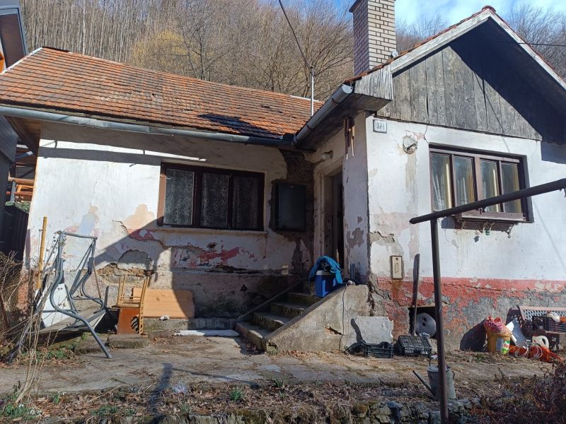 Na predaj chalupa  Banská Hodruša v tichej lokalite - Na obrázku je starší rodinný dom na ulici Banská Hodruša s vyrastenou trávou.