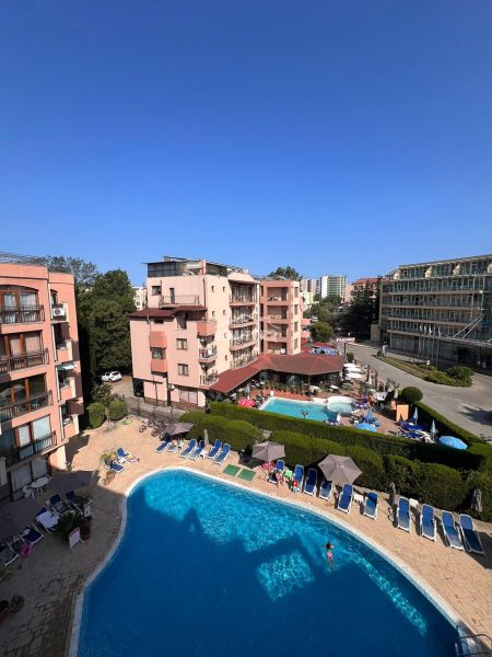 Moderná garsónka (41 m²) s výhľadom na bazén – Rezort ANTARES - Bazénový areál s apartmánovými domami a ležadlami v Slnečnom pobreží.