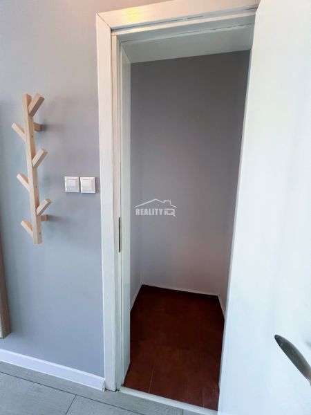 Moderná garsónka (41 m²) s výhľadom na bazén – Rezort ANTARES - Dvere so vstupom do malej miestnosti v garsónke, vedľa stena s vešiakom.