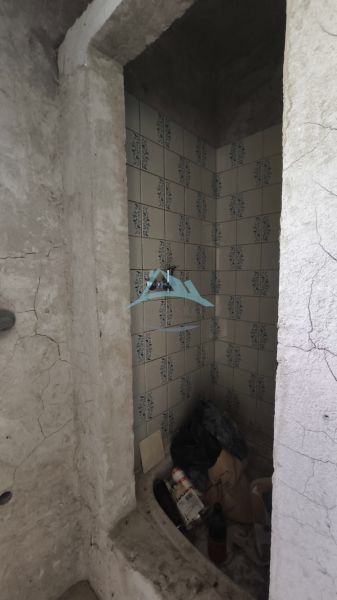3-podlažný vínny domček s vinicou v obci Vinica, okr. V. Krtíš. - Ošarpaná miestnosť s obkladmi vo Viniciach plná harabúrd a stavebných materiálov.
